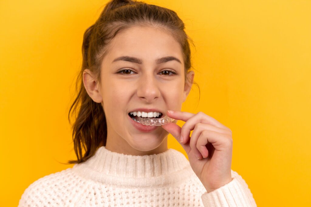 Patient cleaning Invisalign aligners — Invisalign covered by Delta Dental at Coit Dental Frisco TX